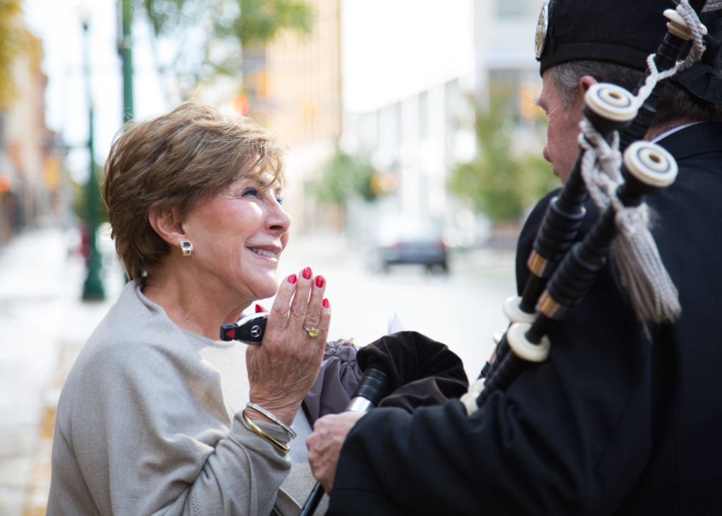 woman greeting man with bagpipes